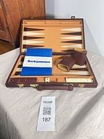 Open backgammon case showing interior field, pieces, shakers, booklet