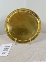 Front view of round brass tray on stand showing overall finish and beaded rim