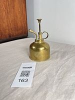 Full view of brass mister with pump and nozzle