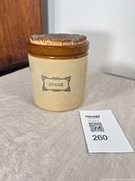 Front view of stoneware sugar container showing printed SUGAR label and shape