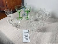 Group of eight assorted vintage crystal and coloured goblets on table