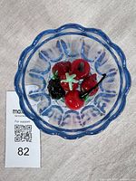 Top view of blue glass bowl containing blown glass fruit