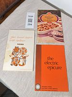 Front covers of three vintage sponsored cookbooks laid on table