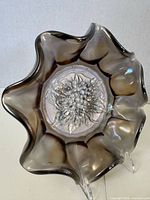 Top view of smoke carnival glass berry bowl showing ruffled rim and embossed grape cluster