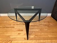 Top view of round glass coffee table showing triangular metal base