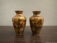 Front view of both cloisonné vases showing floral enamel decoration