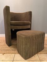 Barrel chair angled with ottoman in front showing full set