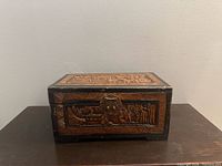 Front view of carved camphor wood box closed