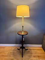 Full view of floor lamp with table and shade illuminated