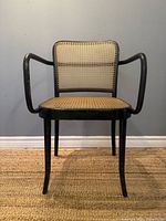Front view of black bentwood armchair with cane seat and back