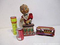 Group shot of bartender toy, kaleidoscope, cable car with size reference can