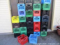 Full stack of multicoloured milk crates in front of garage