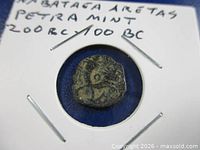 Obverse side of coin in holder showing surface and handwritten ID