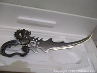 sword in foam box showing dragon handle and jagged blade