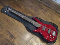 Full view of red Ibanez 6-string bass guitar in gig bag