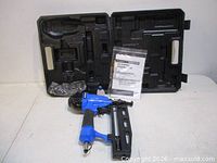 Nailer, open carry case, manual and bagged accessories displayed