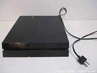 Top view of Sony PlayStation 4 console with attached power cord