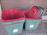 Two stacks of green plastic bins; one stack nested, one holding stacked red lids