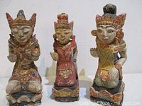 Front view of all three painted wood deity statues