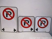 Front view of three No Parking signs showing symbols and arrows