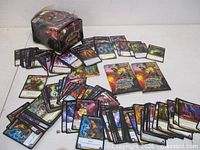 Overview of loose cards spread out with rulebook inserts and damaged display box