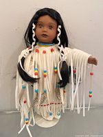 Front view of doll on stand showing full outfit and hair