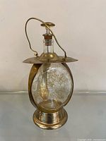 Full view of brass and glass lantern decanter showing overall form