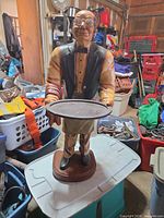 Full view of resin butler statue on bin