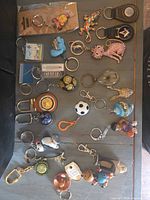 Full layout of approximately 22 keychains showing variety of materials and styles