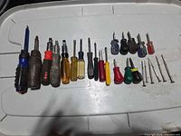 Group overview of all screwdrivers laid out on lid