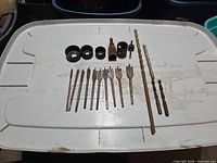 Full layout showing spade bits, hole saw cups, arbor and twist bits on white lid