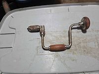 Full view of bit brace drill resting on surface