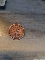 Front of commemorative medal pin showing design details