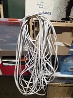 Bundle of flat white Cat 8 cables hanging, overall view