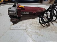 Side view of angle grinder showing brand label, cord, overall wear