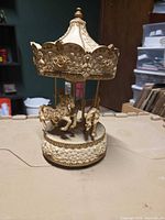 Full view of ivory and gold carousel music box with horses