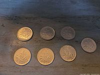 Seven French 1 Franc coins laid out showing reverse sides with dates 1968-1978