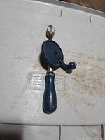 Full view of hand drill front side on lid