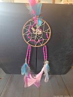 Full view of dreamcatcher showing hoop, web, beads and feathers