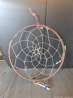 Full view of dreamcatcher showing leather-wrapped hoop and web