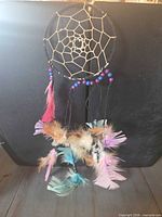Full view of dreamcatcher showing hoop, web, beads and feather strands