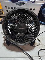 Front view of Honeywell black desk fan showing spiral grill and logo
