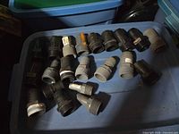 Group of plastic hose barb to NPT adapters displayed in tote