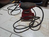 Full view of Hyper Tough corded palm sander with cord coiled