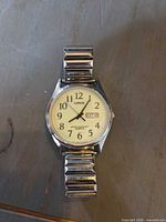 Front view of Lorus watch showing cream dial, Arabic numerals and day-date window