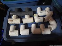 All 13 PVC fittings arranged on blue bin lid