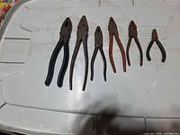 All six pliers laid out on surface
