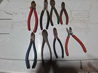 All eight pliers and cutters laid out on white surface