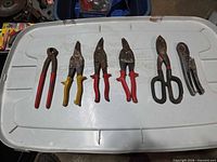 Six hand tools laid out on lid