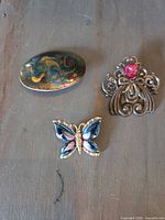 Front view of all three brooches showing designs and colours
